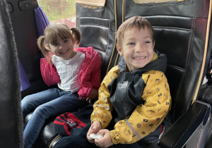 dzieci w autokarze uśmiechają się do zdjęcia